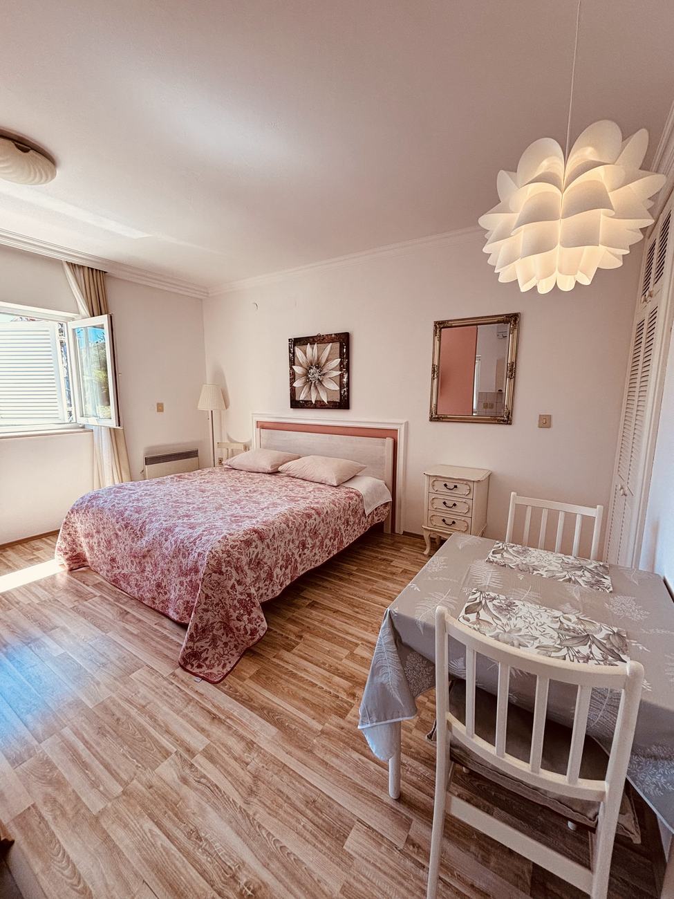 Apartment 1: the bright main room with double bed, dining table and parquet floor