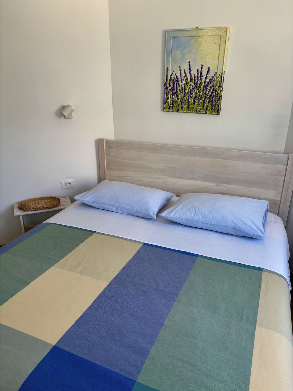 The double bed with a blue and green checked cover