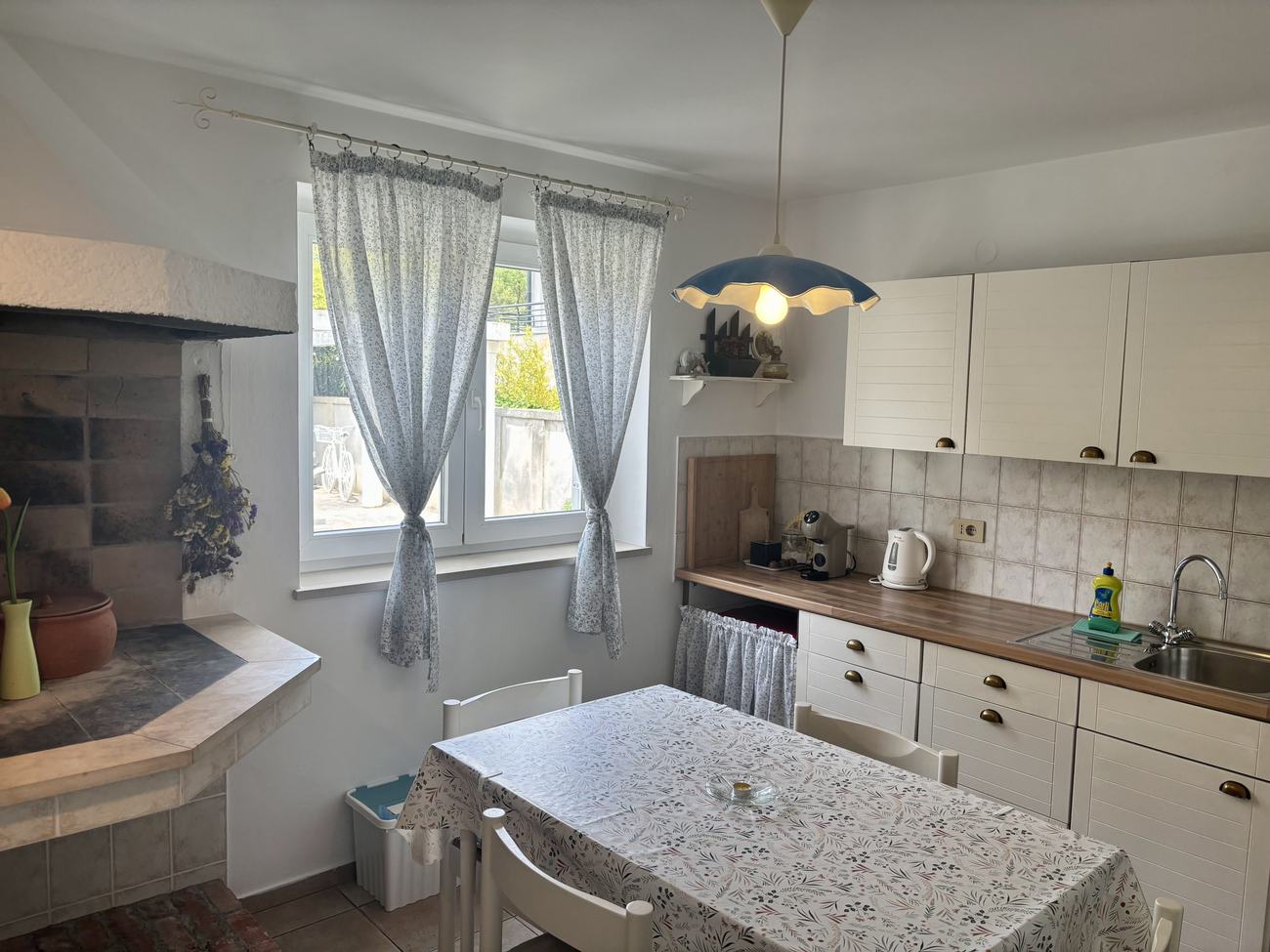 The full kitchen with dining table and lace curtains