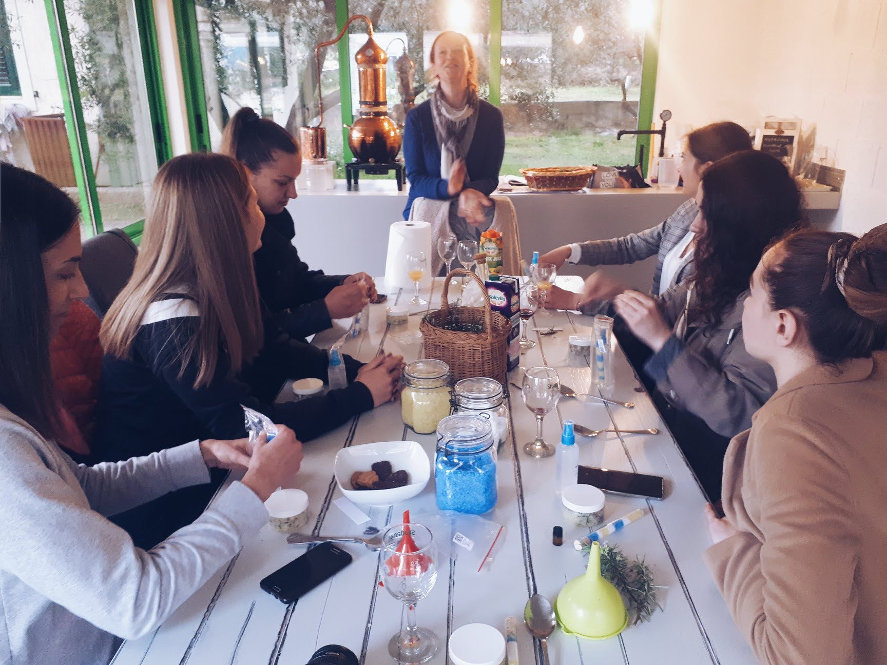 Guests around the workshop table blending bath salts and scrubs